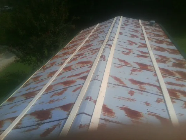 Rusted metal roof panels with new wood purlins before replacement — Storm Damage Roof Repair in Deer Creek by Roofing Brothers