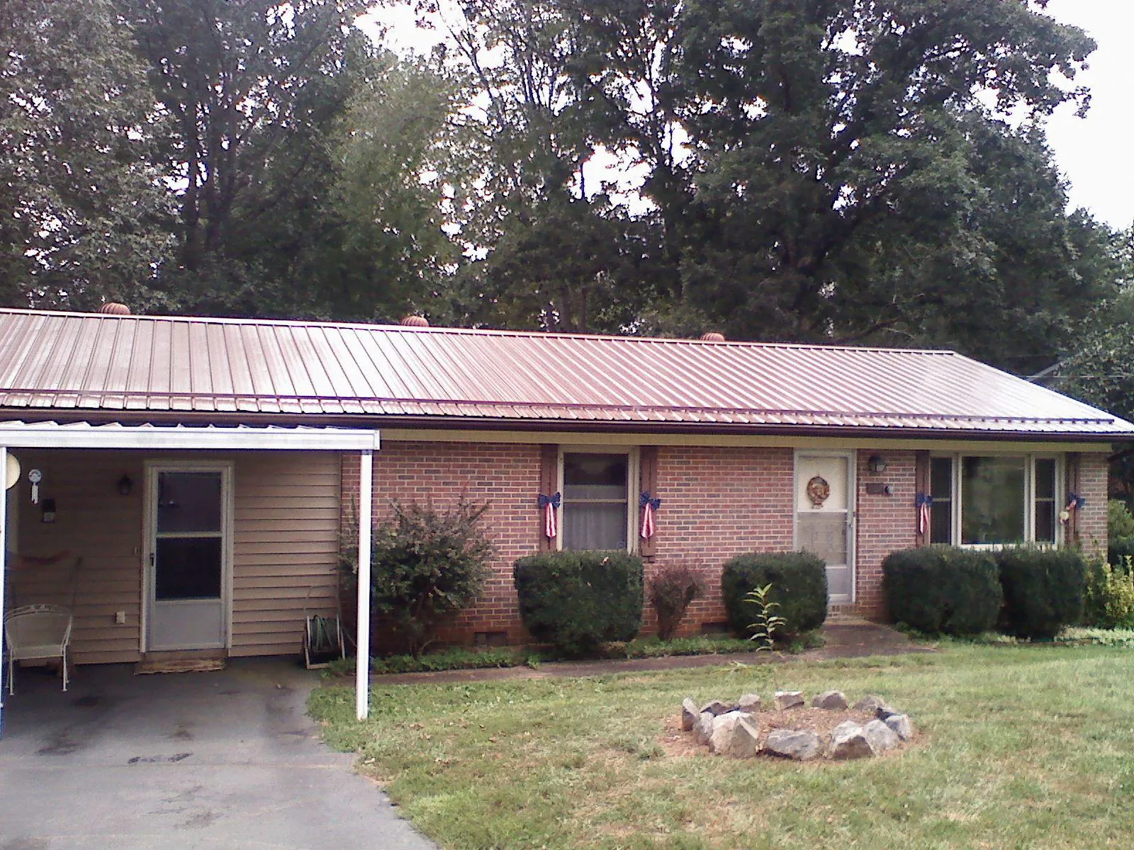 Bronze metal roof and carport on a brick ranch home — Roof Repair work by our crew in Deer Creek